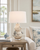 Handmade Thai cream and blue ceramic sea life table lamp displayed on a breezy coastal veranda