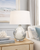 Handmade Thai cream and indigo blue ceramic sea turtle table lamp displayed on a bedside table in a coastal bedroom