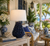 Handmade Thai blue anemone ceramic table lamp styled on a side table in a bright tropical coastal lanai setting.