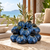Sculptural ocean blue ceramic cluster vase with delicate floral stems in a Mediterranean coastal setting