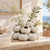 White ceramic cluster vase styled with delicate flowers in an upscale Mediterranean coastal interior