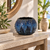 Ocean blue textured ceramic sea urchin vase displayed on a foyer shelf in a warm neutral interior