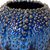 Extreme close-up of glossy ocean blue glaze and raised golden-brown sea urchin texture