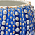 Extreme close-up of glossy ocean blue glaze, white raised details and warm brown accents on a ceramic sea urchin vase
