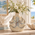 Indigo blue octopus ceramic vase styled with delicate flowers in a bright coastal interior