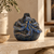 Small handmade blue octopus ceramic vase displayed on a warm limestone shelf in a modern organic interior