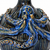 Extreme close-up of sculpted octopus tentacles, textured ceramic and glossy ocean blue glaze with golden-brown accents