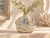 Small octopus ceramic vase with delicate botanical stems in a refined coastal setting
