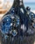 Close-up of sculpted sea turtle detail and deep ocean blue reactive glaze on Thai ceramic vase