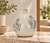 Cream and blue sea turtle ceramic vase displayed in a warm neutral coastal setting