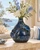 Deep ocean blue sea crab ceramic vase styled with delicate flowers in a coastal interior