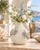 Cream and soft blue sea crab ceramic vase styled with delicate flowers in a coastal interior