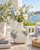 Cream and soft blue sea crab vase styled with delicate flowers on an elegant coastal veranda