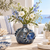 Deep ocean blue sea crab ceramic vase styled with delicate flowers in a coastal interior
