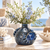 Deep ocean blue sea crab vase styled with delicate flowers on an elegant coastal veranda