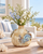 Cream and soft blue sea crab ceramic vase styled with delicate flowers in a coastal interior
