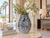 Large handmade blue and white coral vase styled with white orchids in a bright upscale coastal interior