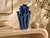 Tall handmade blue coral flower vase on a sculptural console in a warm organic interior