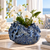 Deep ocean blue sea life ceramic vase styled with orchids in an upscale coastal interior