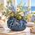 Deep ocean blue sea life ceramic vase styled with delicate flowers on a seaside veranda