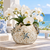 Cream and soft blue sea life ceramic vase styled with flowers in an upscale coastal interior