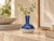 Royal blue and white reactive glaze ceramic vase styled on a warm stone console