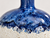 Close-up of handmade Thai ceramic vase showing cobalt blue reactive glaze and textured white finish