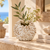 White sculptural barnacle ceramic vase with airy greenery and flowers in a Mediterranean interior