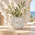 White sculptural barnacle vase with airy floral stems in a Mediterranean-inspired setting