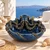 Blue octopus ceramic bowl displayed in a refined seaside lifestyle setting