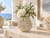 Handmade Thai white coral ceramic vase with floral arrangement in a waterfront coastal setting
