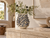 Blue and white coral ceramic vase styled with delicate greenery and flowers on a neutral stone console