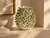 Handmade Thai textured ceramic vase displayed on warm travertine console