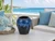 Ocean blue sand dollar ceramic vase styled in a coastal interior beside soft blue seating