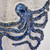 Close-up detail of the sculpted cobalt blue octopus and raised suction cups on the handmade ceramic vase.