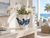 Medium handmade blue and white octopus vase styled with white orchids in a bright coastal interior