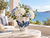 Medium blue and white octopus ceramic vase arranged with white florals in an upscale coastal room setting.