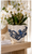 Small handmade blue and white octopus ceramic vase styled with white flowers and greenery in an elegant coastal interior.