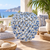 Blue and white undersea mushroom ceramic vase displayed without flowers on a sunlit seaside terrace.