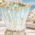 Close-up of the scalloped ceramic vase showing the light aqua glaze and white lava-glazed base detail