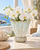 Light aqua blue and white scalloped ceramic vase styled with centered white orchids in an elegant coastal interior