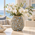 Bouquet De Fleurs earth tone and blue ceramic vase displayed with floral stems in a bright lifestyle setting.