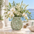 Green Forever Blooms ceramic vase styled with white orchids and delicate flowers in a coastal interior
