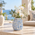 Light blue Bouquet De Fleurs ceramic vase styled with delicate flowers in a bright coastal setting