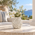 White sculpted flower ceramic vase displayed without flowers on an elegant seaside veranda