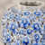 Close-up of sculpted floral relief and blue and cream glaze on handmade Thai ceramic vase