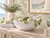 White and green floral ceramic bowl styled against coordinating botanical wallpaper