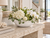 White and green lily ceramic bowl with hydrangeas, orchids and greenery styled on an elegant coastal console