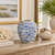 Small light blue floral relief ceramic vase displayed without flowers in a refined coastal interior
