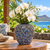 Deep blue Bouquet De Fleurs ceramic vase styled with orchids and delicate flowers in a tropical resort setting
